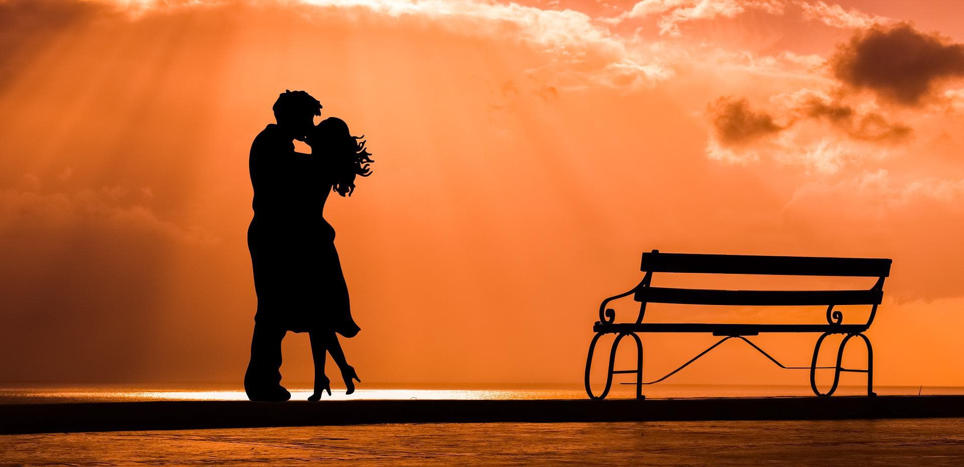 A man and woman kissing behind the sunset (kissing cultures)