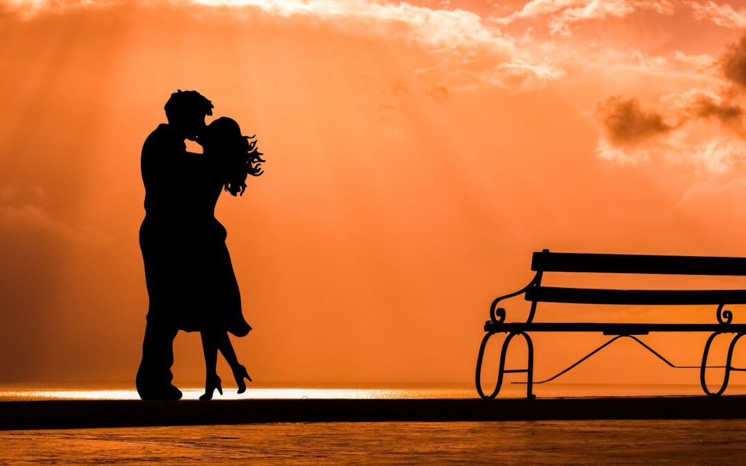 A man and woman kissing behind the sunset (kissing cultures)