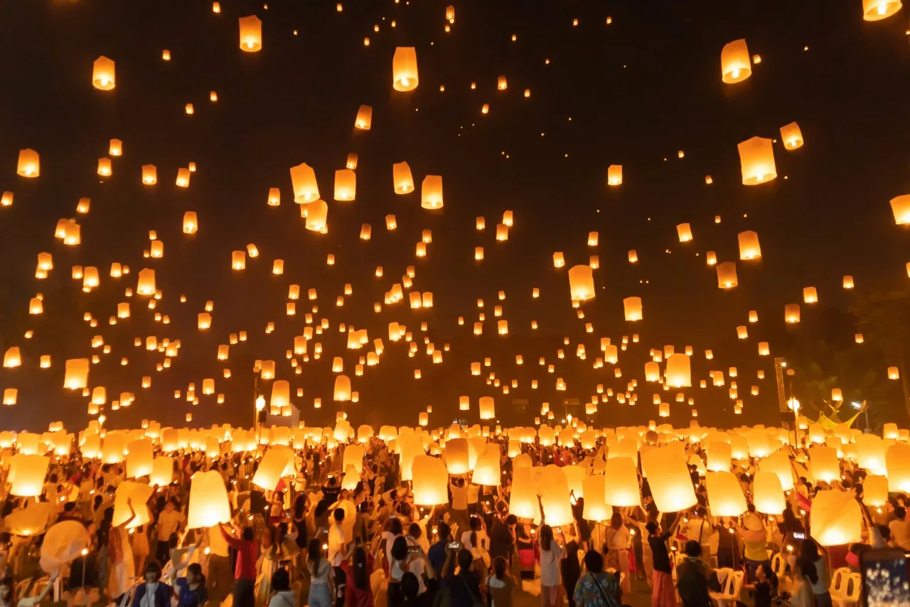 Thai people release sky floating lanterns or lamp to worship Buddha's relics at night. Traditional festival in Chiang mai, Thailand. Loy krathong and Yi Peng Lanna ceremony. Celebration background.